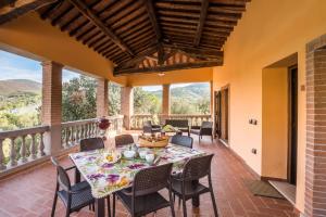 uma sala de jantar com uma mesa e cadeiras numa varanda em Il Castagno Toscana em Campiglia Marittima