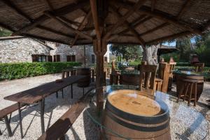 uma mesa de madeira e cadeiras sob um telhado de madeira em Il Castagno Toscana em Campiglia Marittima