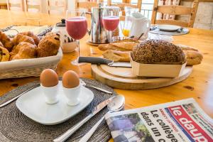 een tafel met eieren en brood en glazen wijn bij Chalet Bluebell in Les Gets