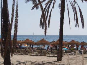 een strand met stoelen en parasols en de oceaan bij Terrace Costa Hotel in Fuengirola