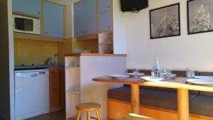 a kitchen with a wooden table with glasses on it at Duplex Le Vogel in Arc 1800