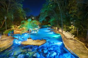 a swimming pool in a park at night at Rio Quente Resorts - Hotel Giardino in Rio Quente