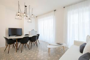 - un salon blanc avec une table et des chaises dans l'établissement La Promenade by Impero House, à Stresa