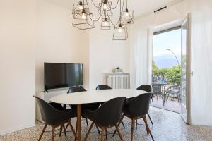 - une salle à manger avec une table, des chaises et une télévision dans l'établissement La Promenade by Impero House, à Stresa