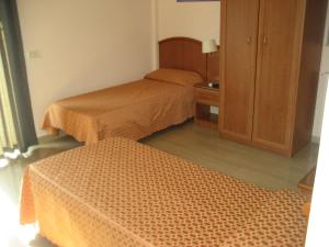 een kamer met 2 bedden en een kast bij Campus Hotel in Bari