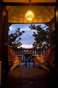 une véranda avec une table, deux chaises et une lampe dans l'établissement The Caves, à Negril