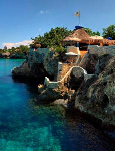 un complexe avec un escalier menant à l'eau et une plage dans l'établissement The Caves, à Negril