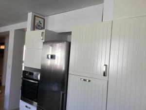 a kitchen with a stainless steel refrigerator and white cabinets at chambre d'hôte-abc in Reims