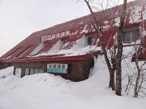 栗原市にある新湯温泉 くりこま荘の雪面の看板をつけた赤い建物