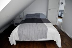 um quarto com uma cama com um cobertor cinzento e branco em Suur-Sepa apartement em Pärnu