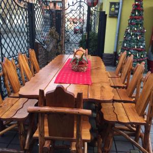 een houten tafel met stoelen en een kerstboom bij Casa Belazur in Deva