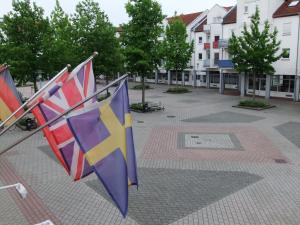 drie vlaggen op een paal op een binnenplaats bij Hotel Garni Classico in Aschaffenburg