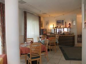 een keuken en eetkamer met tafels en stoelen bij Hotel Garni Classico in Aschaffenburg