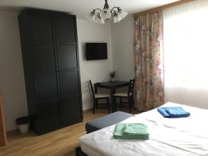 a bedroom with a black cabinet and a table at Gasthof Ogertschnig in Klagenfurt