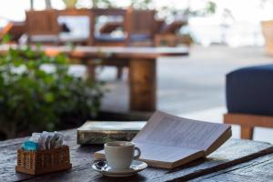 un libro e una tazza di caffè sul tavolo di Villa dos Corais a Morro de São Paulo