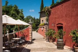 um pátio exterior com mesas e cadeiras e um edifício vermelho em Borgo Grondaie em Siena