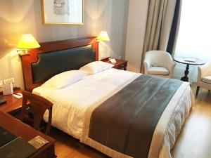 a bedroom with a large bed and a table and chairs at Theoxenia Palace in Athens