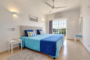 een slaapkamer met een blauw bed en een raam bij 3HB Clube Humbria - All Inclusive in Albufeira