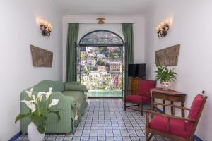 uma sala de estar com um sofá e uma janela em Hotel Poseidon em Positano