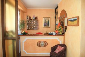 a room with a wall with a shelf and a chair at Hotel Les Saisons in Saint Vincent