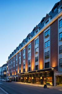 un gran edificio de ladrillo en una calle de la ciudad en Warwick Brussels - Grand Place en Bruselas