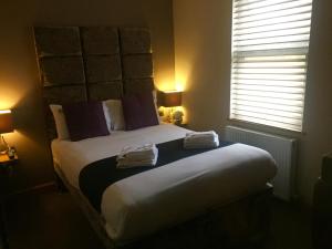 1 dormitorio con 1 cama grande y toallas. en Homestay Hotel Heathrow, en Hounslow