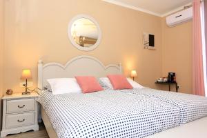 a bedroom with a white bed and a mirror at Shabby chic rooms in Zadar