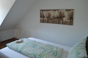 a bedroom with a bed with a painting on the wall at BnB zum Schlüssel in Unterehrendingen