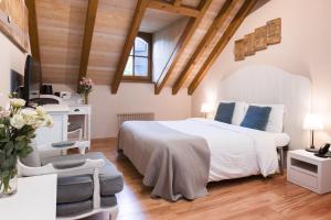 um quarto com uma grande cama branca num quarto com tectos em madeira em Auberge Communale de Carouge em Genebra