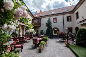 an outdoor patio with tables and chairs and flowers at Hotel Octarna - Free parking in Kroměříž