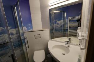 a bathroom with a toilet and a sink and a shower at Hotel Sonnekalb in Naumburg