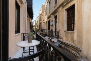 une petite table sur un balcon dans une ville dans l'établissement Nonnalena Boutique Hotel, à La Canée