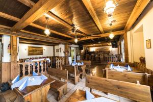 een leeg restaurant met houten tafels en banken bij Valašský Hotel a Pivní lázně OGAR in Luhačovice