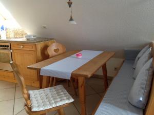 a small kitchen with a wooden table and a chair at Urseetalblick in Lenzkirch