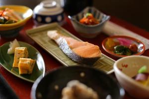 een tafel met borden en schalen van voedsel bij Hinode Ryokan in Ise