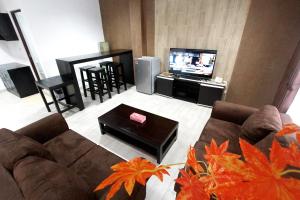 salon z kanapą i telewizorem w obiekcie BeOne House Jogja w mieście Yogyakarta