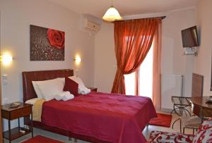 Habitación de hotel con cama roja y ventana en Anesis, en Ioannina