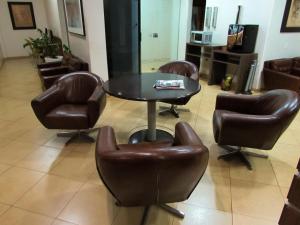 une table, trois chaises, une table et des chaises dans l'établissement Dourados Center Hotel, à Dourados