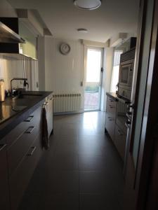 a large kitchen with a sink and a microwave at SkyLinePamplona in Pamplona