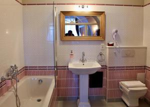 a bathroom with a sink and a tub and a toilet at Penzion Kasper Cyklopenzion in Jindrichuv Hradec