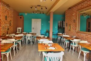 a restaurant with wooden tables and chairs and a brick wall at Penzion Kasper Cyklopenzion in Jindrichuv Hradec