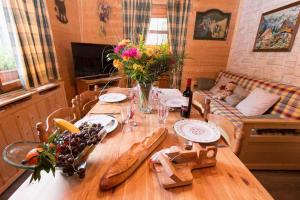 een eettafel met een lange houten tafel met bloemen bij Les Allamands in Morzine