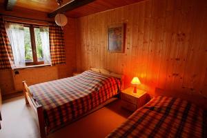 een slaapkamer met 2 bedden en een lamp erin bij Les Allamands in Morzine