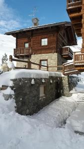 a log cabin with snow in front of it at Pianeta Oro Apartments in Livigno