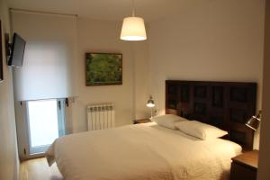 a bedroom with a large white bed and a window at Apartaments Centre Figueres in Figueres