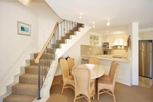 a dining room and kitchen with a table and chairs at Tranquil Little Cove Unit, Pool Escape in Noosa Heads