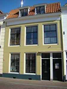 un edificio giallo con finestre e tetto di B&B Vierwinden a Vlissingen