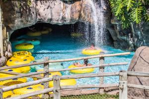 een groep mensen in een zwembad met een waterval bij Rio Quente Resorts - Hotel Luupi in Rio Quente