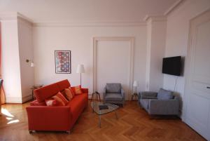 uma sala de estar com um sofá vermelho e duas cadeiras em Appartements in zentraler Lage em Tübingen