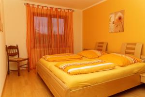 a bedroom with a bed with orange walls and a window at Ferienwohnung Kaufmann in Baiersbronn